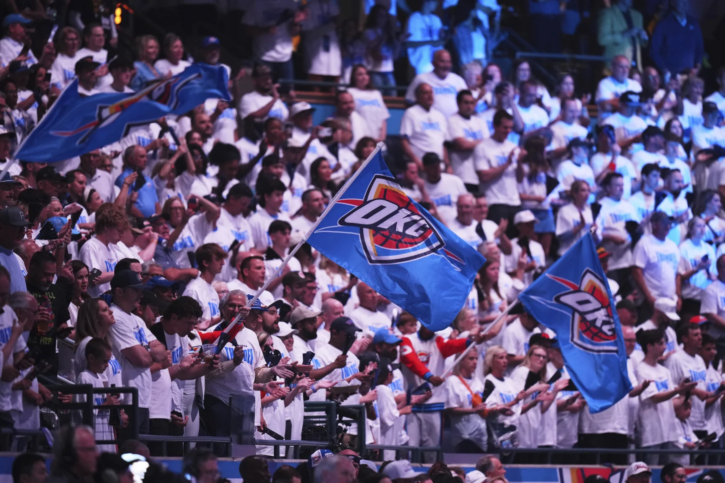 Oklahoma City Thunder fans cheering loudly in the stands during NBA Finals Game 1, showing support for their favorite players