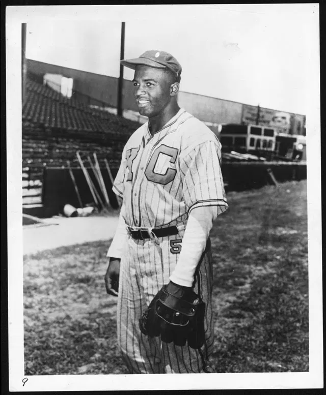 Black and white photo of Jackie Robinson walking onto the field in 1947.
