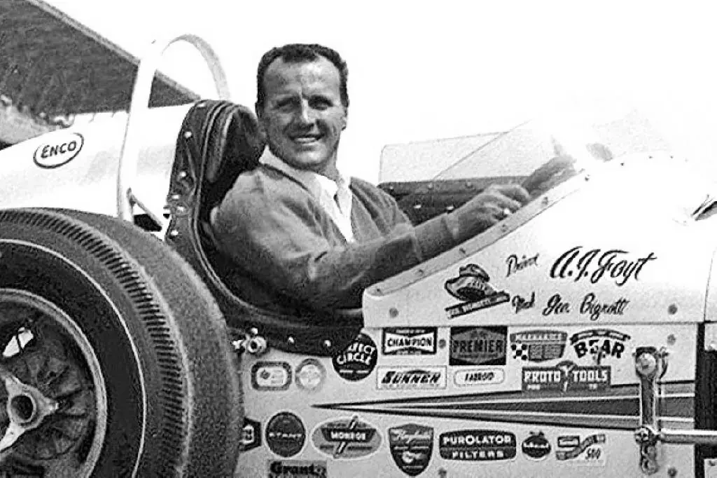 AJ Foyt smiling inside his racing car, a symbol of AJ Foyt's Untold Speed Records and legendary confidence