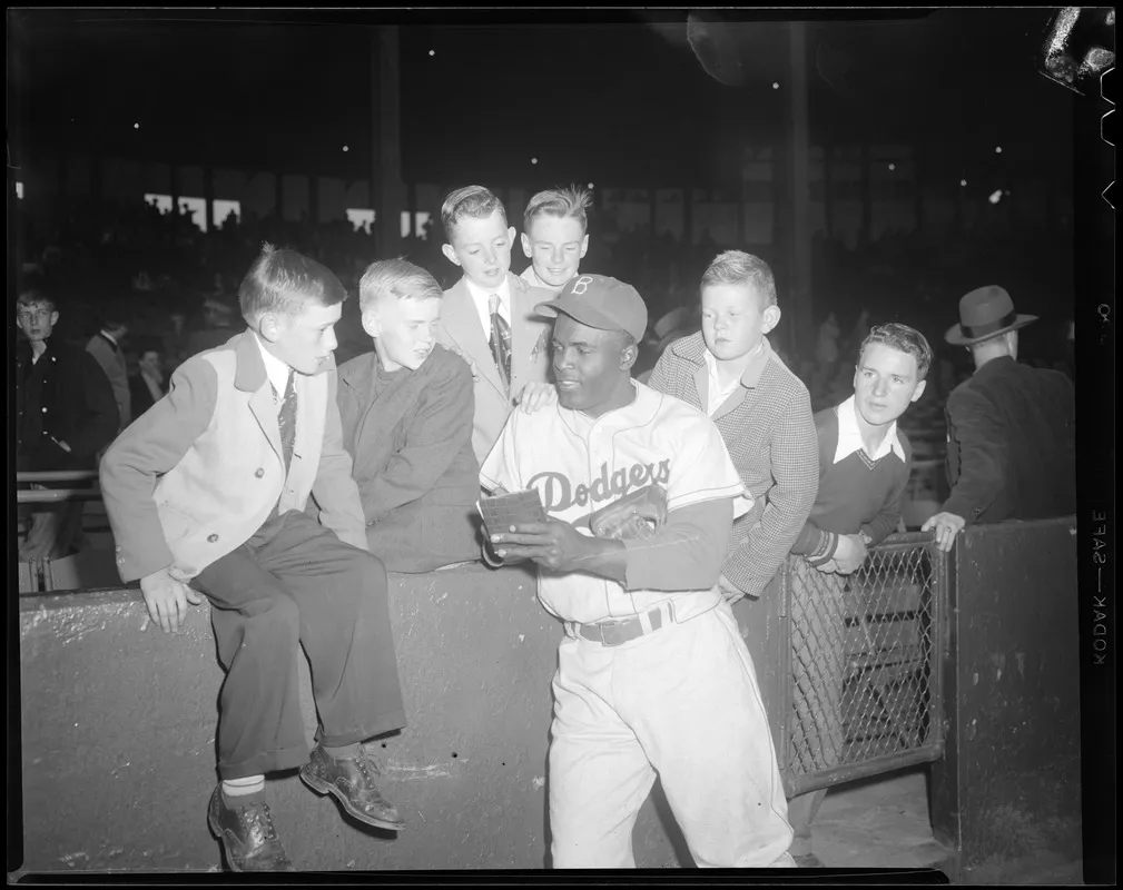 Robinson signing autographs for young fans after a game.