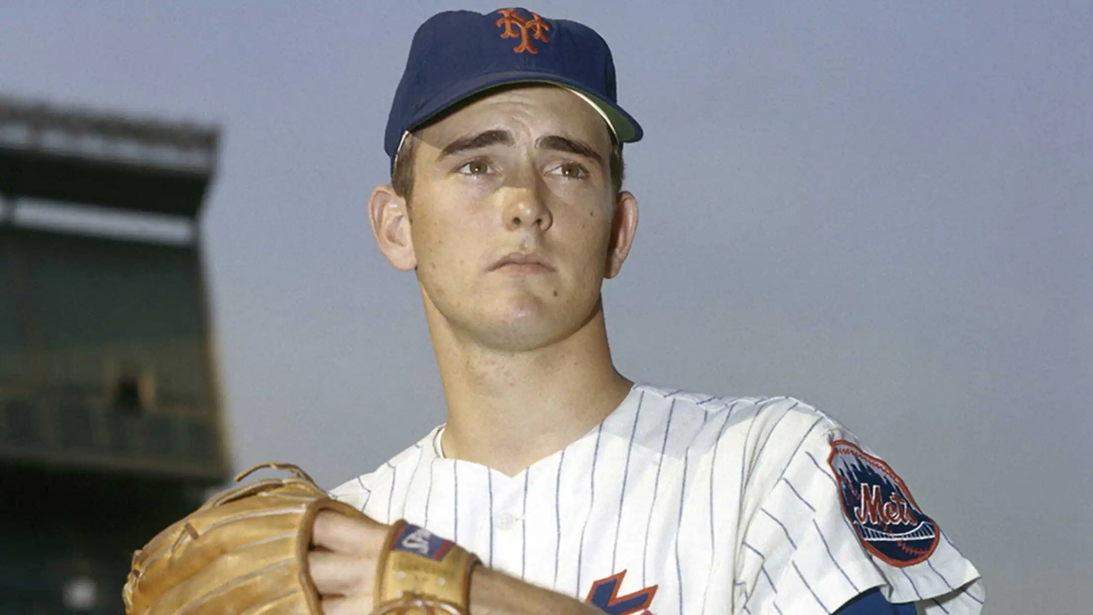 A young Nolan Ryan in his early MLB years, wearing a classic uniform and winding up for a pitch with fierce focus